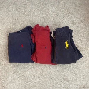 Hoodies från Ralph Lauren (Bulk) - Säljer tre hoodies från Ralph Lauren i olika färger. Två är blå med olika färger på loggan och en är röd. Perfekta för en avslappnad stil med klassisk design och bekvämt material.