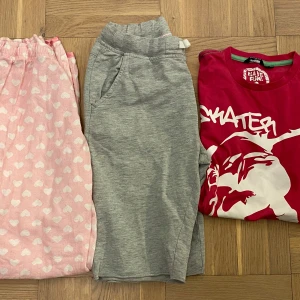 Klädpaket i stl. 158/164! - Klädpaket stl. 158/164! Innehåll: Ett par bekväma grå shorts med dragsko i midjan. De har praktiska fickor på sidorna. En rosa T-shirt med skateboard tryck. Fina rosa pyjamasbyxor med hjärtan. 
