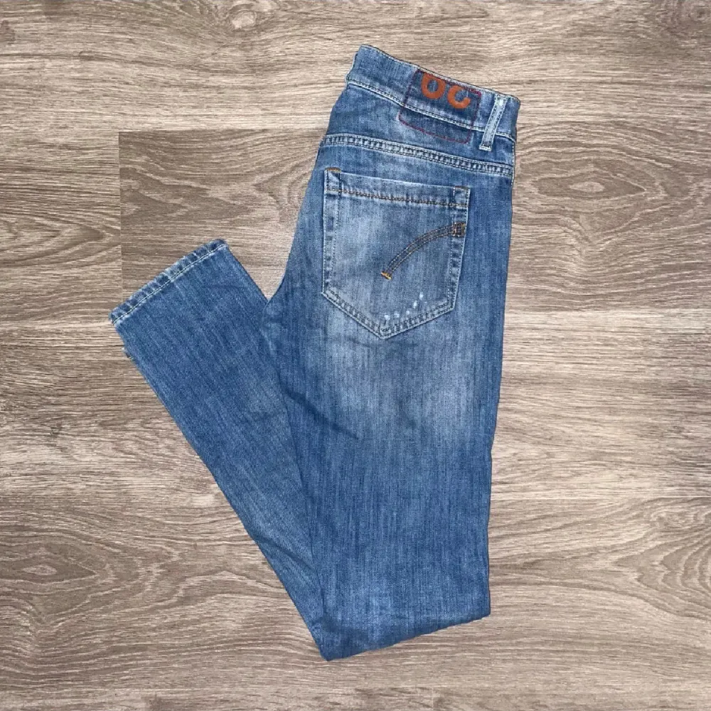 Säljer ett par blå jeans med coola slitningar och en klassisk femficksdesign. De har en knappgylf och är perfekta för en avslappnad stil. Passar bra till sneakers eller kängor.. Farkut & Housut.