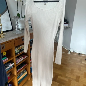 Beige ribbad långklänning - Säljer en stilren beige bodycon dress. Klänningen är ribbad och har en rund halsringning med långa ärmar. Perfekt för en elegant och avslappnad look. Passar bra till både vardag och festliga tillfällen.