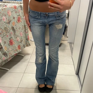 Ljusblå bootcut lågmidjade replay jeans - Snygga ljusblå bootcut jeans från Replay med slitna detaljer på låren. De har en låg midja och är bootcut. Skitsnygga nu till våren! 