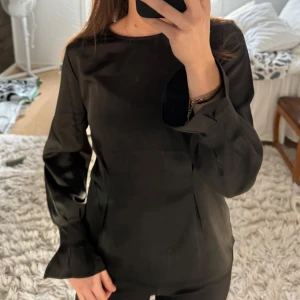 Svart långärmad topp - Snygg svart satin topp/blus. Passar mig som vanligtvis har storlek 36