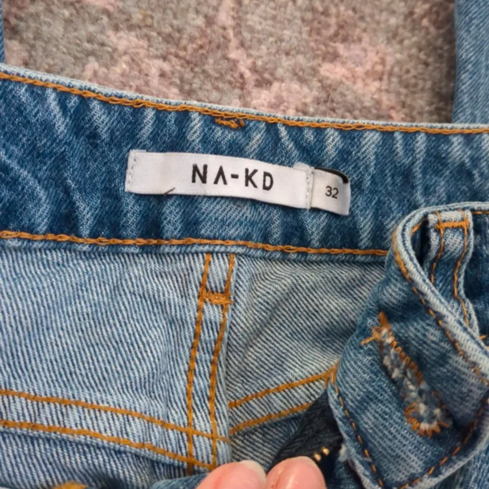 Säljer ett par klassiska blå jeans från NA-KD. De har en normal passform med dragkedja och knapp framtill. Perfekta för en avslappnad stil.. Farkut & Housut.