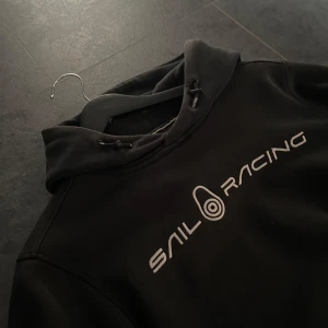 Svart hoodie från Sail Racing - Svart Sail Racing hoodie i storlek S, Använt ett par gånger men är i gott skick för endast 250kr🤯