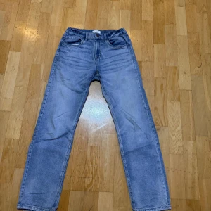 Blå jeans från Lindex - Säljer ett par klassiska blå jeans från Lindex. De har en straight passform och en knappgylf. Perfekta för en avslappnad stil.