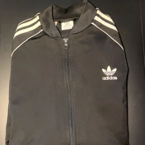  Adidas dragkedja tröja  - Säljer en svart dragkedja tröja från Adidas.