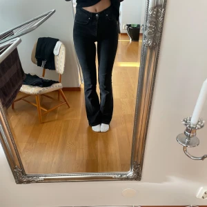 Svarta jeans med hög midja - Snygga svarta jeans med hög midja och klassisk femficksdesign. Något urtvättade. 