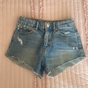 Blå jeansshorts från Gina Tricot - Säljer ett par snygga blå jeansshorts från Gina i storlek 32, bara använda ett fåtal gånger och är i bra skick 