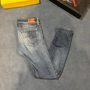 Blå jeans från Replay - Snygga blå jeans från Replay med en klassisk femficksdesign och en lätt tvättad look. Perfekta för en avslappnad stil. Märkeslappen i läder ger en extra touch av kvalitet.