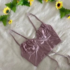 Rosa satin korsett från Shein - Snygg rosa korsett i satin från Shein med smala axelband och snörning i ryggen. Perfekt för en stilren look med en touch av elegans. Passar bra till både jeans och kjol.