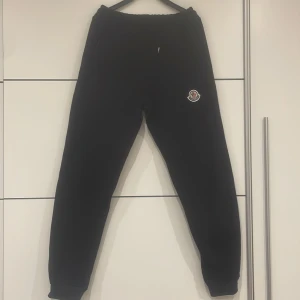  Moncler - Snygga svarta mjukisbyxor från Moncler med elastisk midja och broderad logga på benet. Perfekta för en avslappnad stil. Byxorna har en klassisk passform och är tillverkade i ett mjukt material för extra komfort.
