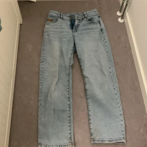 Ljusblå jeans från L.O.G.G. - Säljer ett par ljusblå jeans från L.O.G.G. med klassisk femficksdesign och rak passform. Jeansen har en knappgylf och är tillverkade i denim. Perfekta för en avslappnad stil.