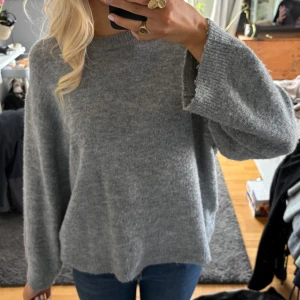 Grå stickad tröja - Mysig grå stickad tröja med långa ärmar och en avslappnad passform. 