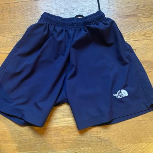Svarta shorts från The North Face - Snygga svarta shorts från The North Face med elastisk midja och logga på benet. Perfekta för en aktiv livsstil.