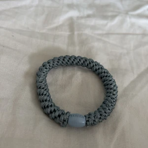 Ljusblått armband från Kknekki - Snyggt och elastiskt ljusblått armband från Kknekki. Perfekt som accessoar för att ge en stilren touch till din outfit. Armbandet har en flätad design och är både praktiskt och trendigt och väldigt snyggt!                                                                Köpt för 50kr