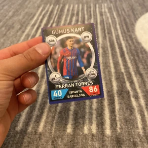 Fotbollskort med Ferran Torres - Fotbollskort med Ferran Torres i Barcelonas matchtröja. Kortet har text på turkiska och visar spelarens position som RW, samt statistik som 40 i försvar och 86 i anfall. Kortet är märkt som 'Gümüş Kart'.
