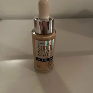 Maybelline Super Stay 24H Skin Tint - Maybelline Super Stay 24H Skin Tint i nyansen 05.5. Denna foundation ger en långvarig täckning och innehåller vitamin C för en fräsch look. Perfekt för en jämn och naturlig finish. Mer än halva kvar 