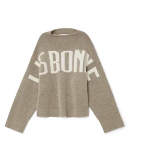 Lis Bonne Beige stickad tröja med text - Säljer en beige stickad tröja med vit text 'LISBONNE' över bröstet. Tröjan har en hög krage och långa ärmar. Den har en avslappnad passform. Använd ett fåtal gånger. 