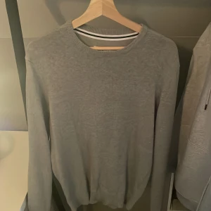 Grå tröja från Pier One - Säljer en stilren grå tröja från Pier One. Tröjan har en klassisk rund halsringning och långa ärmar, perfekt för en avslappnad look. Passar bra till både jeans och chinos.