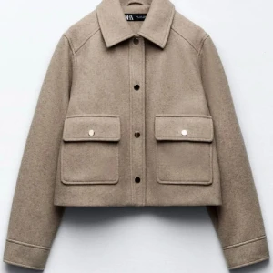 Vår jacka Zara - Snygg beige jacka från Zara med en klassisk krage och knappar framtill. Jackan har två stora fickor med lock och knappar på bröstet. Perfekt för en stilren look. Storlek L men sitter som på bilden som en storlek S. BUDA🥰