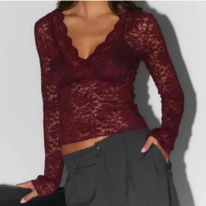 Vinröd spetsblus - Snygg vinröd spetsblus med v-ringning och långa ärmar. Perfekt för en kväll ute eller en speciell tillställning. Blusen har en elegant och feminin design som framhäver din stil.