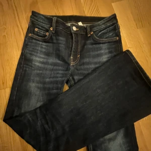 Mörkblå jeansbyxor från Weekday - Snygga mörkblå jeansbyxor med klassisk femficksdesign och knappgylf. Perfekta för en avslappnad stil. De har en rak passform och är tillverkade i slitstarkt denim.