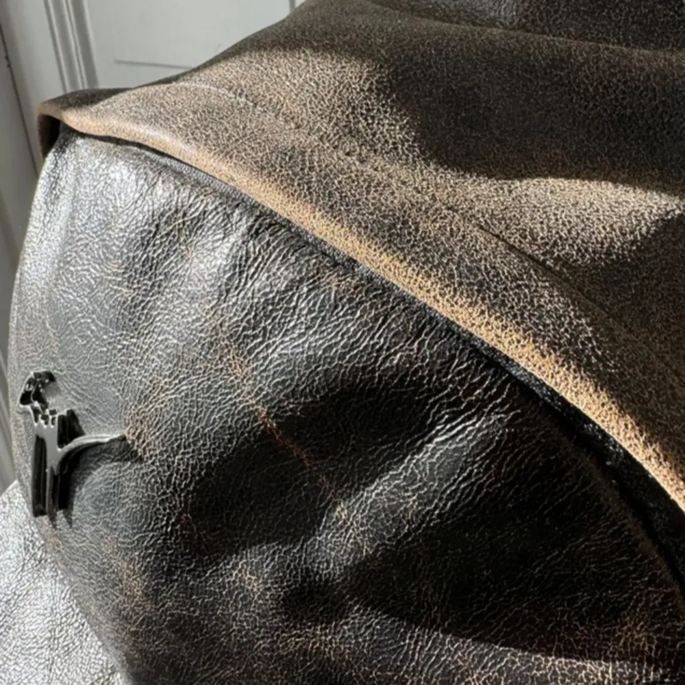 Snygg brun ryggsäck i skinn med ett stilrent märke på framsidan. Ryggsäcken har en praktisk dragkedja och en klassisk design som passar perfekt för vardagsbruk. Den har en rymlig huvudficka och en mindre ficka framtill för enkel åtkomst till dina saker.. Laukut & Käsilaukut.