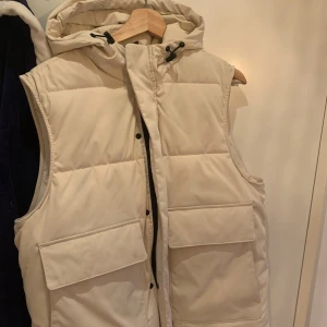 Vit väst med luva från Zara - Säljer en snygg vit väst från zara, västen är knappt använd och är perfekt för sommaren. 