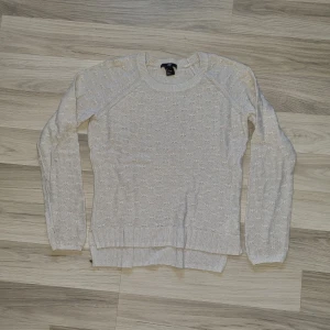 Ljusgrå stickad tröja från H&M - Säljer en Ljusgrå stickad tröja från H&M med ett diskret mönster. Tröjan har långa ärmar och ribbstickade muddar vid ärmslut och nederkant.