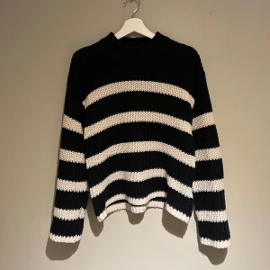Svart och vit randig stickad tröja  - Säljer en snygg svart och vit randig stickad tröja från Vero Moda då den inte kommer till användning, använd fåtal gånger så nästan som ny.