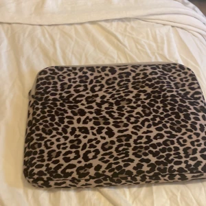 Leopardmönstrad datorväska - Snygg och trendig datorväska med leopardmönster. Perfekt för att ge din laptop ett stilfullt skydd. Väskan har en dragkedja för säker förvaring och är lätt att bära med sig.