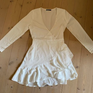 Vit klänning - Vit långärmad klänning perfekt till studenten!🌷 Mycket fint skick då jag aldrig använt den och säljes eftersom jag hittat en annan jag gillar. Storleken är rätt också. Det finns ett ”spänne” som visas på bild 3 som ändrar urringningen och en väldigt diskret dragkedja under höger arm (bild 4)💕 Önskas fler bilder är det bara att fråga!