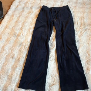 Mörkblåa från Juicy Couture (köpta på bubbleroom) - Snygga mörkblå byxor från Juicy Couture. Byxorna har en avslappnad passform och är tillverkade i polyester och elastan för extra komfort. Perfekta för en stilren look. Dessa är i storlek S men kan även passar M, de är lite för långa för mig som är 164cm. Jättefina, sköna och snygga. Säljer dessa då dem inte används, hoppas på att hitta någon som använder dessa super mysiga byxorna. Super super bra skick. Knappast använda, pris kan diskuteras!💞hör av er vid frågor🩷🩷