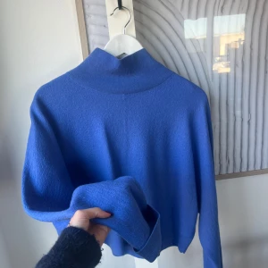 Blå fin stickad tröja COS  - Säljer en stilren blå halv polotröja med ribbad krage. Perfekt för kyligare dagar och ger en snygg look. Tröjan har långa ärmar och en mjuk känsla. märke COS buda gärna! 