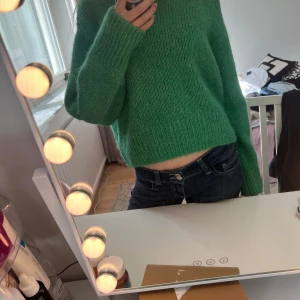 Grön stickad tröja - Säljer en mysig grön stickad tröja med långa ärmar. Perfekt för kyligare dagar och ger en skön och avslappnad look. Tröjan har en enkel design som gör den lätt att matcha med olika outfits.