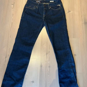 Mörkblå jeansbyxor från Replay - Säljer ett par mörkblå jeansbyxor från Replay, modell Pearl. Klassisk femficksdesign med raka ben och snygga kontrastsömmar. De är ganska gamla men knappt använda stolek 29/34 men ganska små o storleken