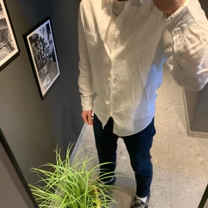 Vit skjorta från H&M Essentials - Klassisk vit skjorta från H&M Essentials, modell No 17. Skjortan har lång ärm, knäppning framtill och en rak passform. Perfekt till många olika stilar och enkel att matcha med jeans eller chinos.