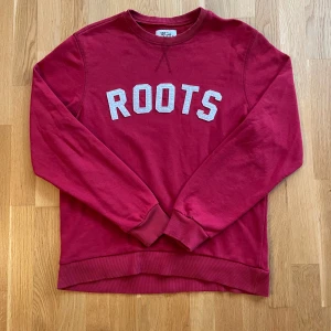 Röd sweatshirt  - Röd sweatshirt från lager 157 med vit text framtill. Klassisk rund halsringning och ribbade muddar vid ärmslut och nederkant. Perfekt för en avslappnad stil.