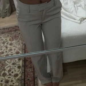 Beiga kostymbyxor med normal passform - Snygga beiga kostymbyxor med raka ben och klassisk midja. Byxorna har hällor för bälte och diskreta fickor framtill. Perfekta för en stilren och clean look. Maddie byxor från bikbok, säljer pga råkade beställa dubbelt pch hann ej returnera, älskar dessa, otroligt bekväma. Nypris 499kr