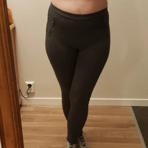 Nya mörkgrå leggings från Hollister strl S / 36 - Mörkgrå leggings från Hollister med dragkedjedetaljer framtill. Byxorna har en tight passform och är tillverkade i ett mjukt och stretchigt material som sitter skönt mot kroppen. Perfekta för en avslappnad och stilren look. Det står M men dom är små så en s p.s ej rivktiga fickor 