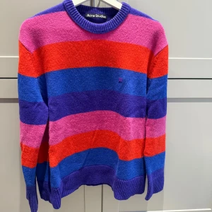 Tröja från Acne Studios - Säljer en stickad tröja från Acne Studios i färgglada ränder. Använd 2-4 gånger, i nyskick. 