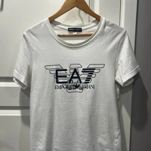 Armani T-shirt - Vit T-shirt från armani. Den är lite använd men kommer i bra skick. Den kommer i storlek S. Skriv gärna för fler bilder eller andra frågor!