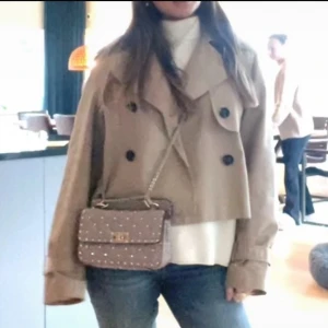 Beige trenchcoat💖💖 - Säljer en beige croppad trenchcoat med dubbelknäppning och stora slag. Perfekt för dig som vill ha en klassisk men trendig look. 