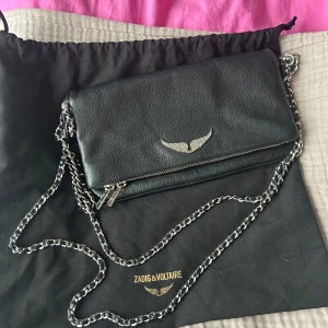 Svart axelväska från Zadig & Voltaire - Snygg svart axelväska i skinn från Zadig & Voltaire. Kort och långt band ingår samt dustbag. Inköpt för 3600:- jättefint skick!