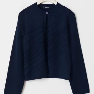 Svart stickad kofta från Gina Tricot - Mysig svart stickad kofta med rund halsringning och en knapp framtill. Perfekt att slänga över en topp för extra värme. Långärmad och enkel i modellen.