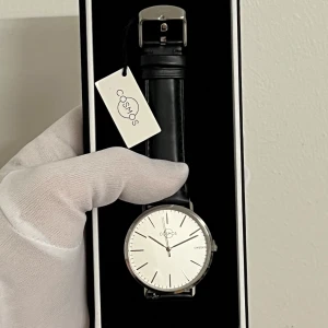 Först till kvarn - i äkta safir glas och äkta läder , Oanvänd original Cosmos Sweden Klocka - Jupiter – Solar Pris: 599 SEK  Nyckelfunktioner: • Urtavlans diameter: 40 mm • Tjocklek: 7 mm • Urverk: Japan • Material: Rostfritt stål 316L • Glas: Safirglas • Armband: Grått snabbfäste i äkta läder (20 mm bredd) • Vattentålighet: 3 ATM  Ytterligare information: • Mått: 40 mm • Vikt: 45 g • Material: Rostfritt stål, safirglas, äkta läder • Stil: Tidlös och unisex – passar alla 