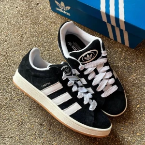 Adidas Campus 00 - Svarta Adidas Campus sneakers med vita ränder 00, Använda 1 gång endast så i princip nya! Kvitto finns!