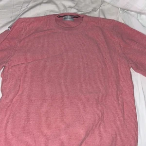 Rosa stickad tröja från Moncler - Säljer en rosa stickad tröja från Moncler i storlek S. Tröjan har rund halsringning, långa ärmar och Moncler-logga på ena ärmen. Perfekt för dig som gillar klassisk och stilren design.