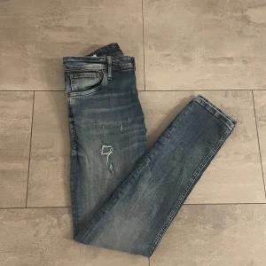 Jack and Jones jeans med slitningar - Säljer nu dessa feta Jack and Jones jeansen med slitningar. Storleken är 29/32 och modell Slim fit/Glenn. Hör av er vid funderingar.