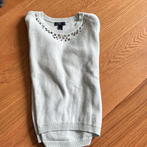 Ljusblå stickad tröja med pärldetaljer - Superfin ljusblå stickad tröja från H&M med pärldetaljer runt halsringningen. 